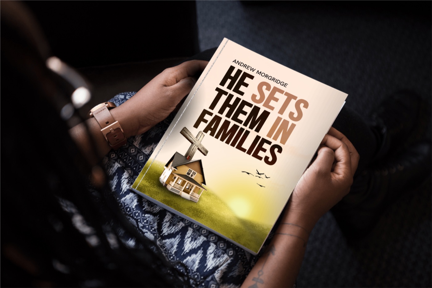 A reader holding He Set Them In Families