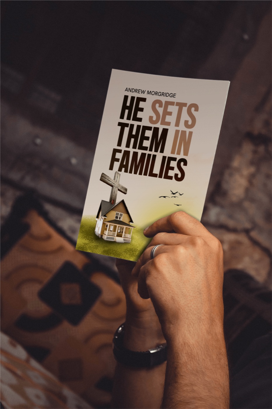 Holding a copy of He Set Them In Families