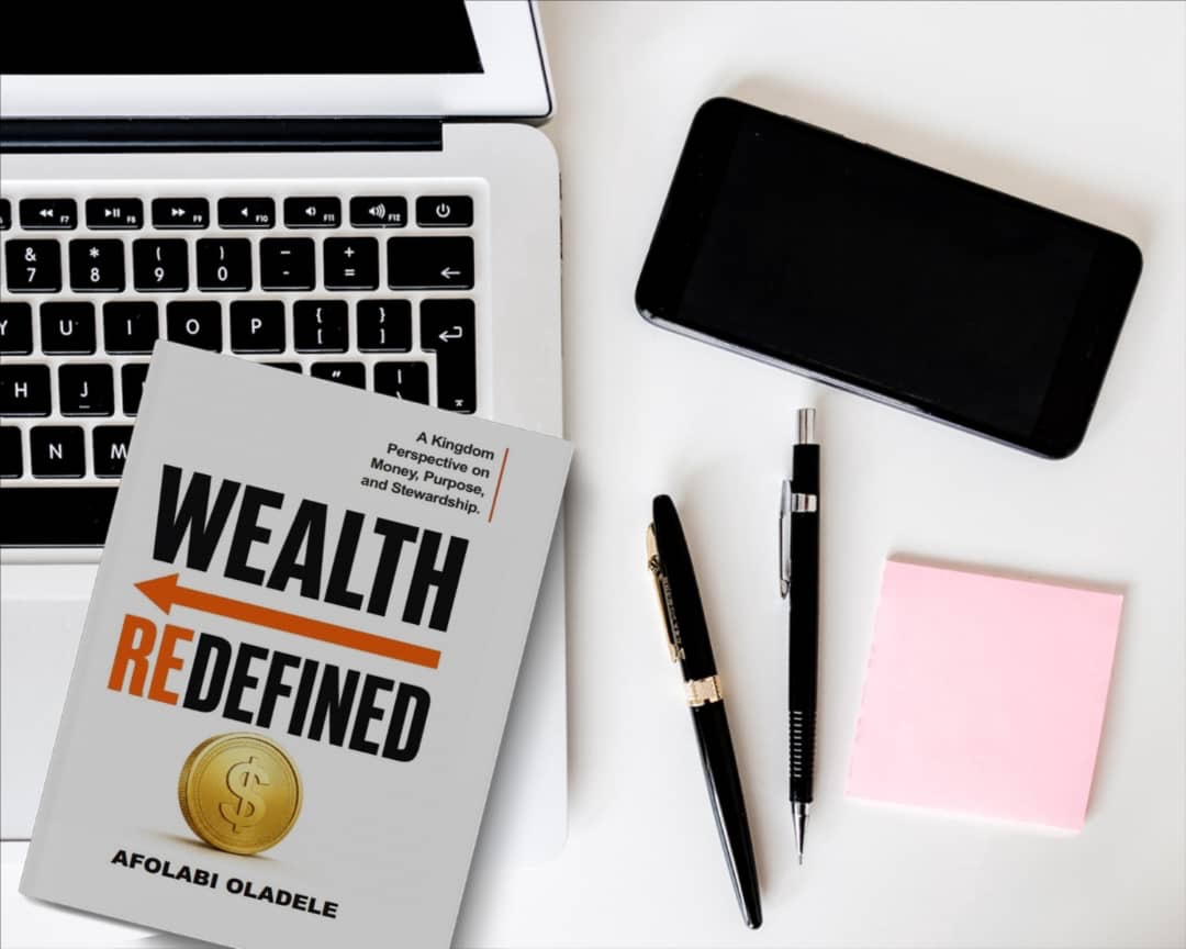 Wealth Redefined on a desk with a laptop